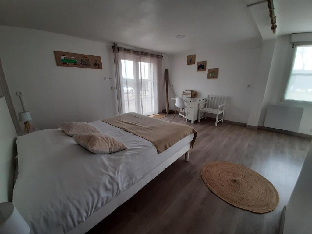 a bedroom with a large bed and a table at Escales dans les dunes in Créances