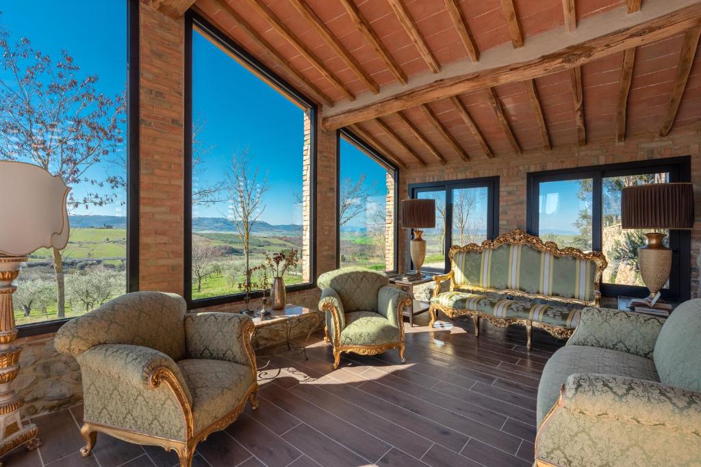 a living room filled with furniture and large windows at Il Miraggio in Val d'Orcia Relais & Spa in San Quirico dʼOrcia