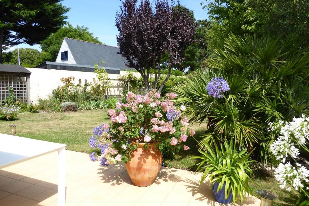 un grand vase rempli de fleurs dans une cour dans l'établissement REF 064 Grande maison de famille pour huit personnes Kerjouanno Tumiac ARZON, à Arzon