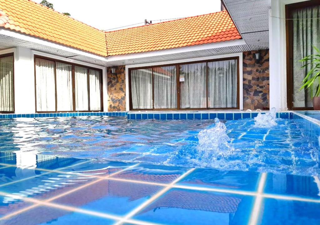een zwembad met blauw water voor een gebouw bij Baan Golden Pool Villa in Sam Roi Yot