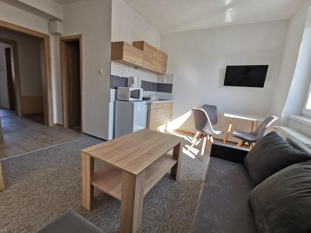 a living room with a couch and a table and a kitchen at Apartmány Star in Kežmarok