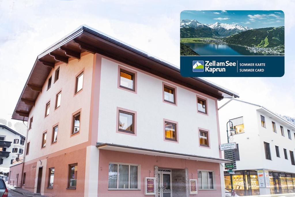 a building in front of a lake and mountains at Seilergasse Apartments by we rent, SUMMERCARD INCLUDED in Zell am See