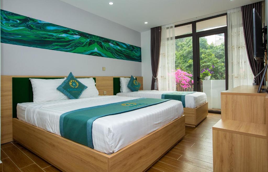sypialnia z 2 łóżkami i dużym oknem w obiekcie Emerald Hotel Cát Bà w mieście Cát Bà