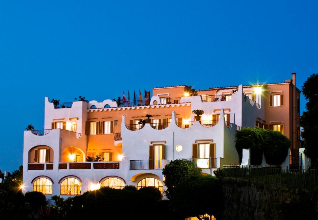 - un grand bâtiment blanc la nuit dans l'établissement Hotel Casa Di Meglio, à Ischia