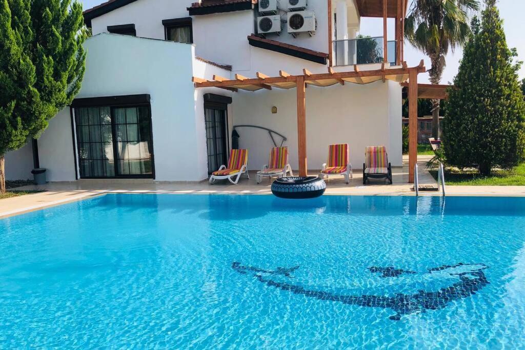 a swimming pool in front of a house at Fun&Sun Luxury River Villa With Amazing Landscape in Belek