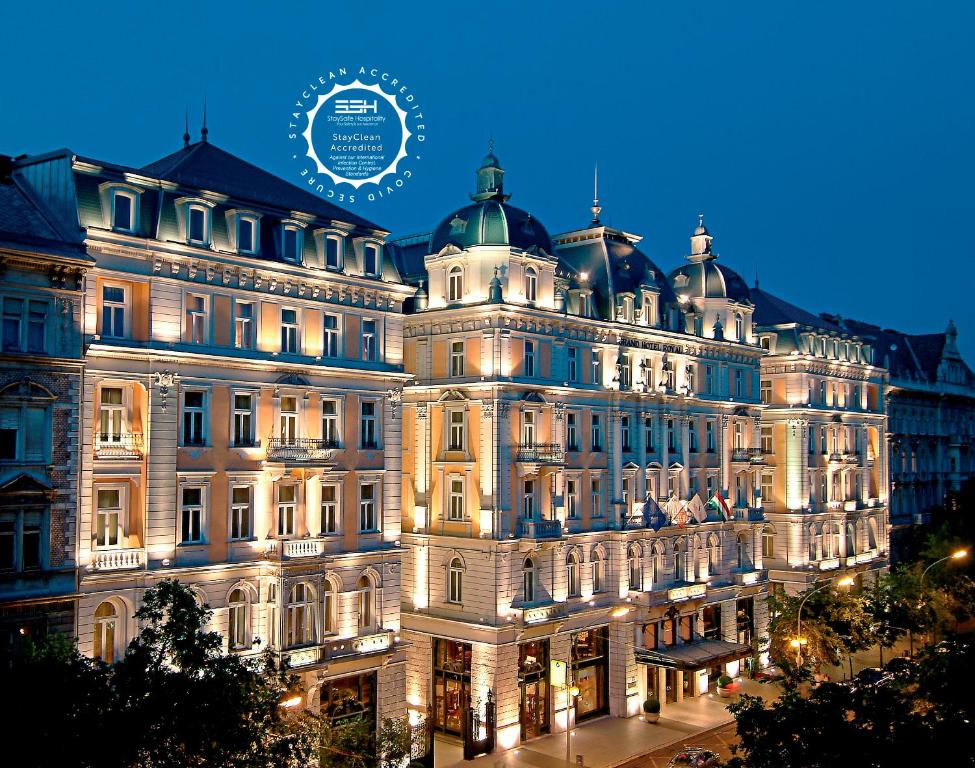 un grand bâtiment éclairé la nuit dans l'établissement Corinthia Budapest, à Budapest