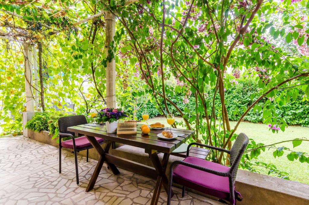 einen Tisch und Stühle auf einer Terrasse mit einem Baum in der Unterkunft Apartments L&M in Dubrovnik