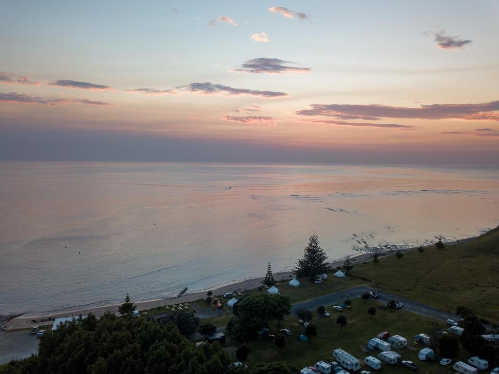 eine Luftansicht auf einen Strand bei Sonnenuntergang in der Unterkunft Tatapouri Bay in Gisborne