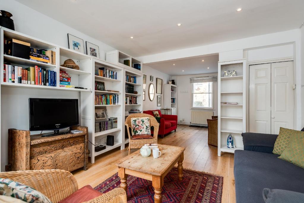 ein Wohnzimmer mit weißen Regalen und einem TV in der Unterkunft Characterful & Cosy Jericho House (sleeps up to 8) in Oxford
