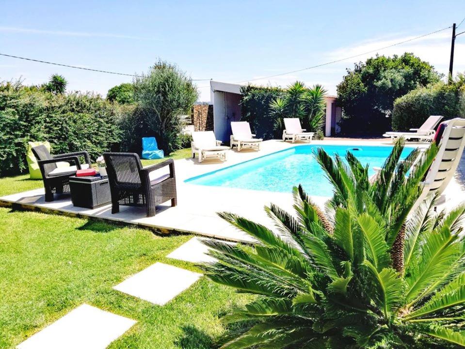 a backyard with a pool with chairs and a table at Casa AMOReira de Óbidos in Amoreira