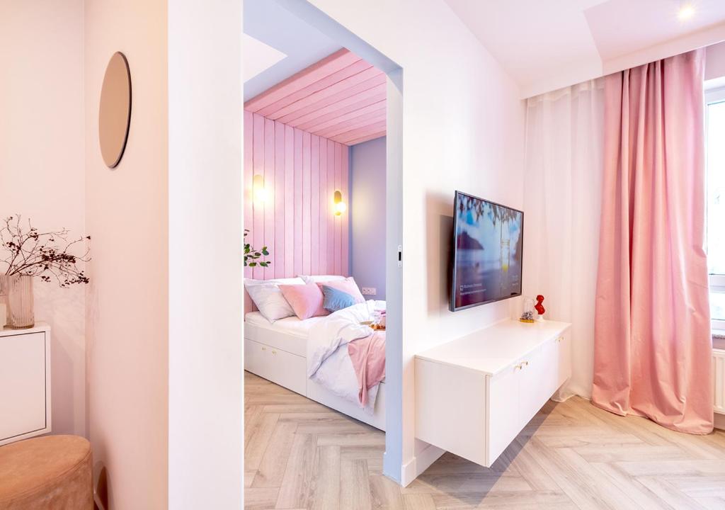 Dormitorio pequeño con cama y TV en Apartamenty Flat White Obywatelska 49, en Zielona Góra