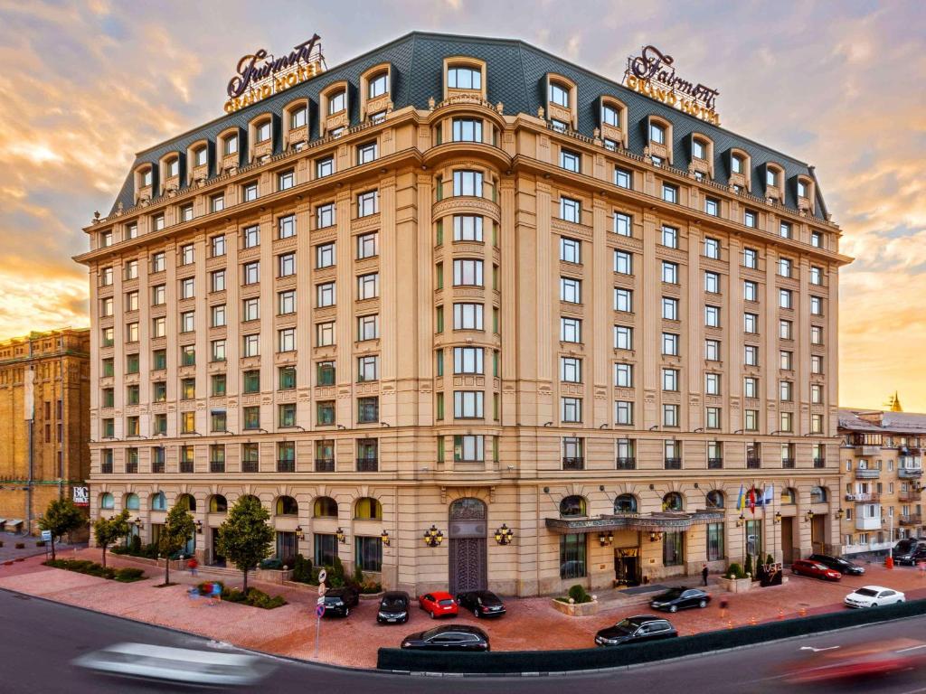 a large building with cars parked in front of it at Fairmont Grand Hotel Kyiv in Kyiv