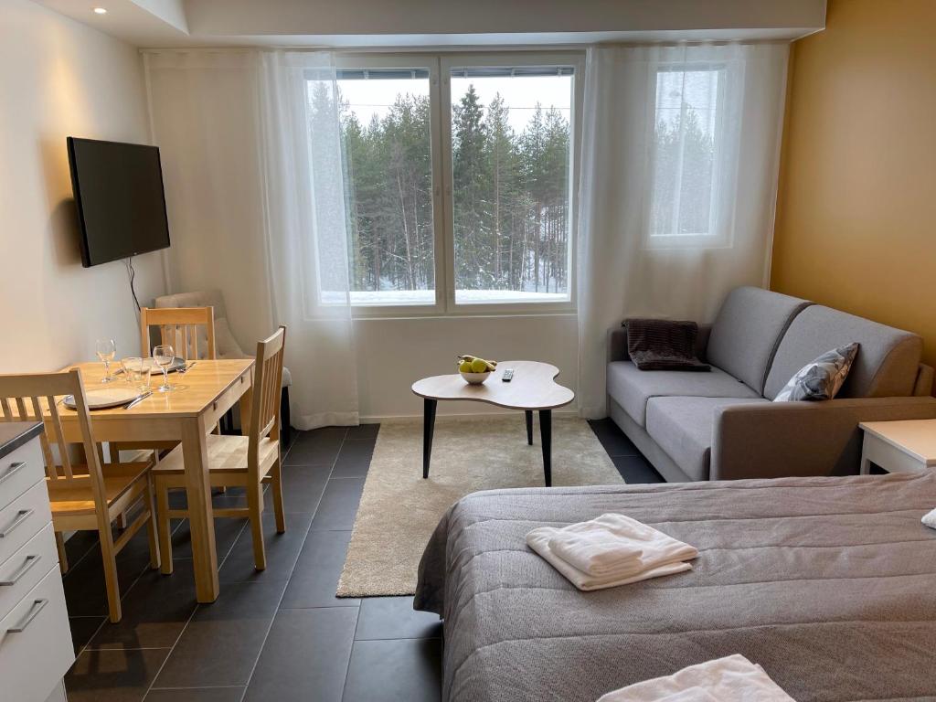 een kamer met een bed, een bank en een tafel bij Hotel Lost in Levi in Levi