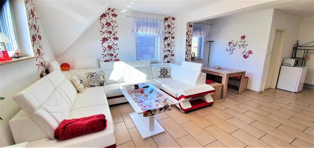 a living room with white furniture and a table at Fewo Traum in Neppermin