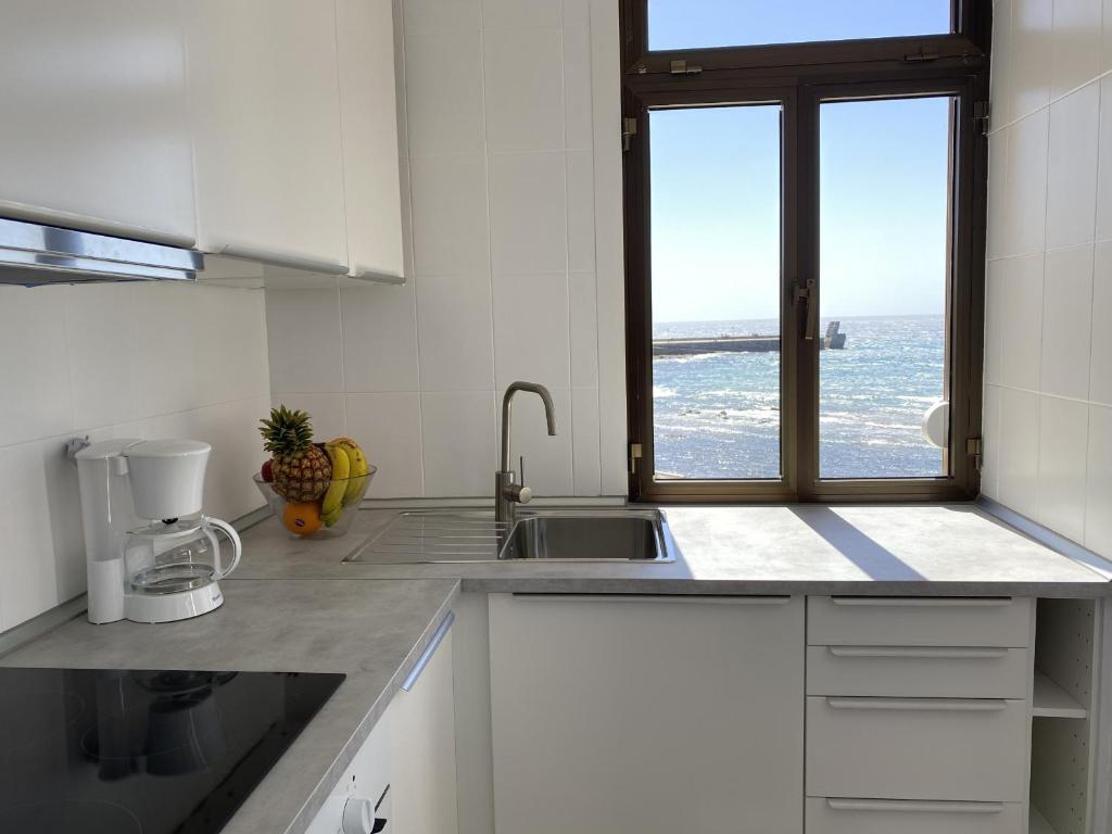 a kitchen with a sink and a window at Arinaga Colors, tu casa en la playa in Arinaga