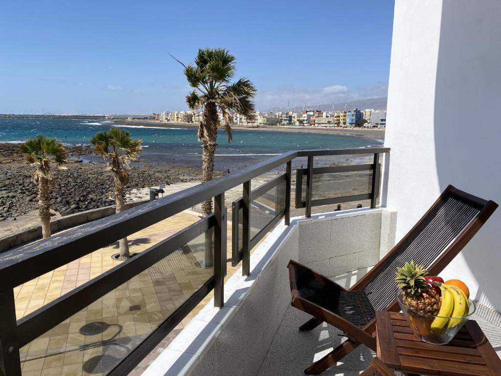 a balcony with a bench and a view of the beach at Arinaga Colors, tu casa en la playa in Arinaga