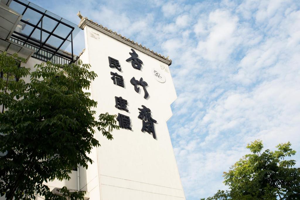 una torre di un orologio alto e bianco con un orologio sopra di 杏竹斋客栈 a Yi