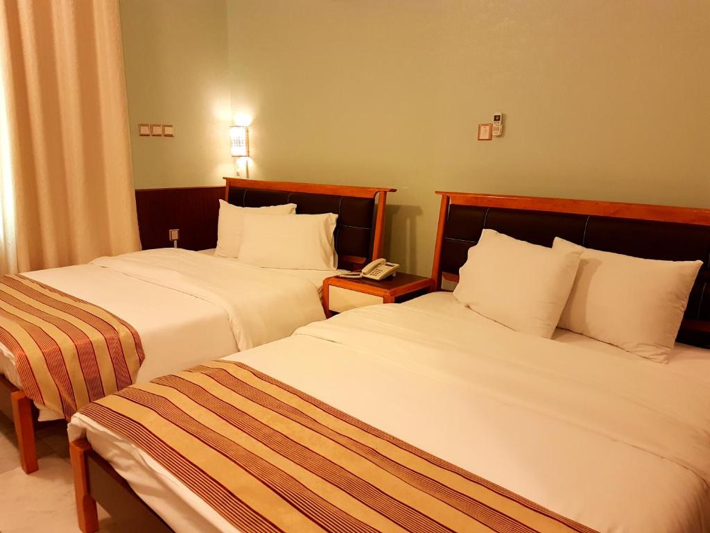 Postel nebo postele na pokoji v ubytování Al Ghubrah Plaza Hotel