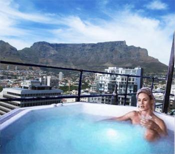 a woman in a bath tub on top of a building at Manhattan Lofts in Cape Town