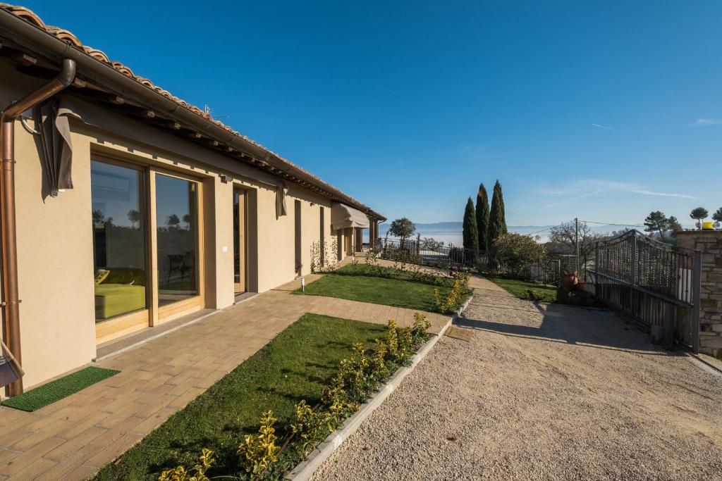 a house with a pathway leading to a yard at Agriturismo Umbrian Sunrise in Cannara