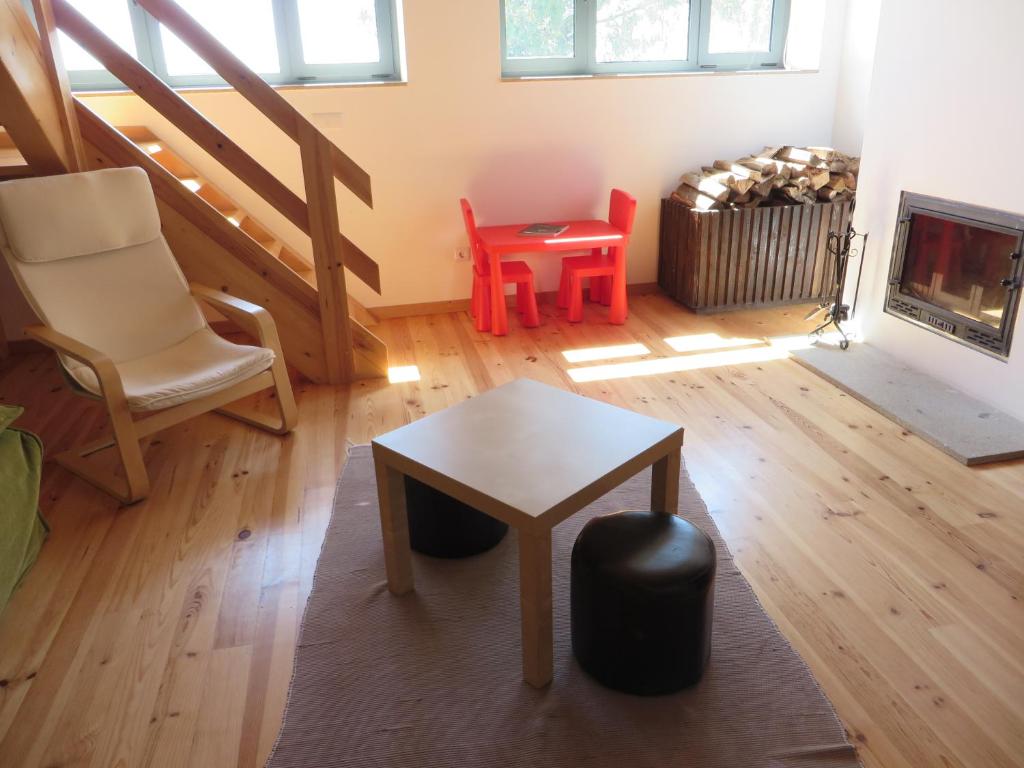 a living room with a table and chairs and a fireplace at Casa de Sao Mamede in São Mamede