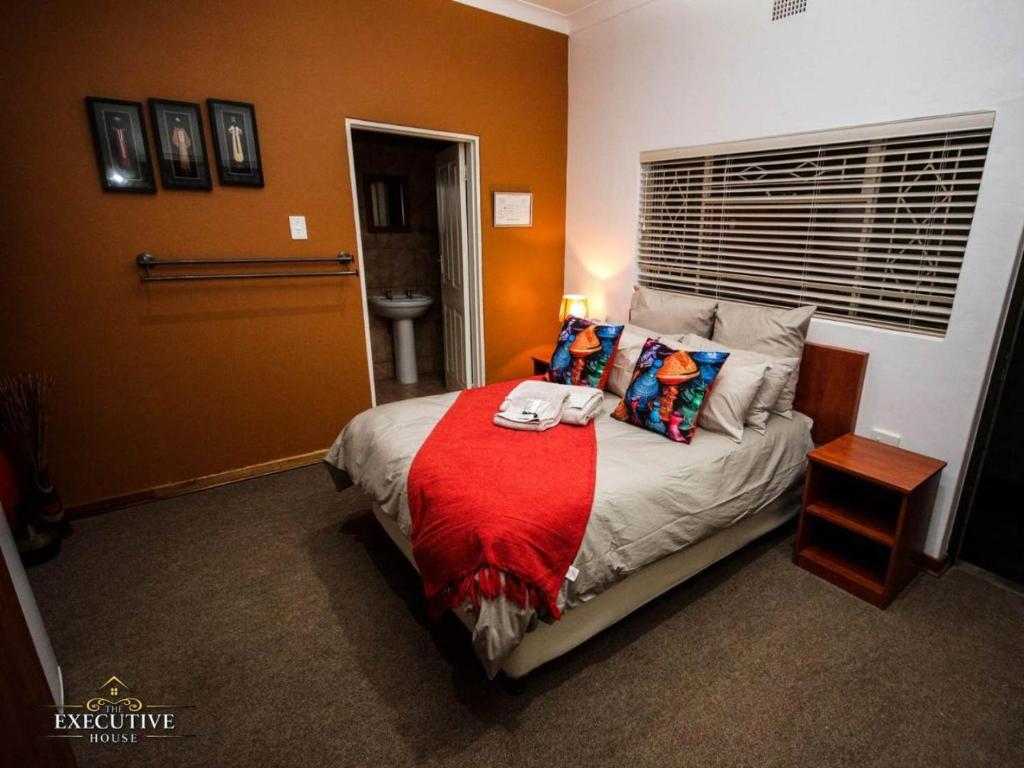 ein Schlafzimmer mit einem Bett mit einer roten Decke in der Unterkunft The Executive House in Newcastle