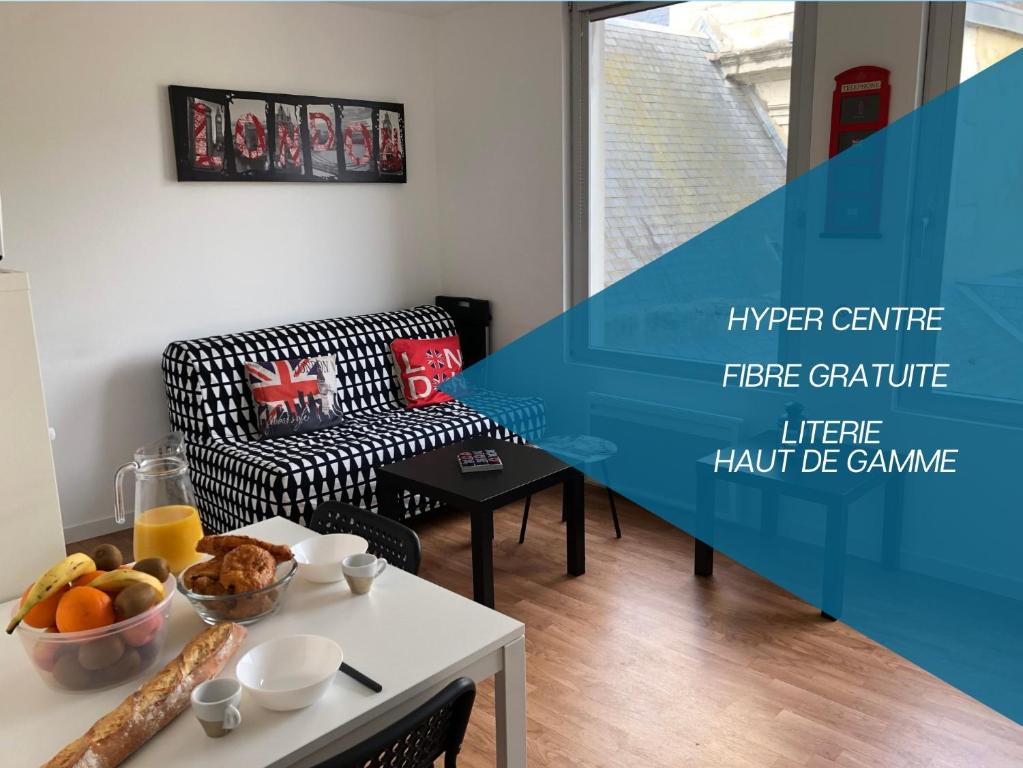 uma sala de estar com uma mesa e uma cadeira em HYPER CENTRE - WIFI FIBRE GRATUIT - JERGWELOH - Le Londonien em Caen