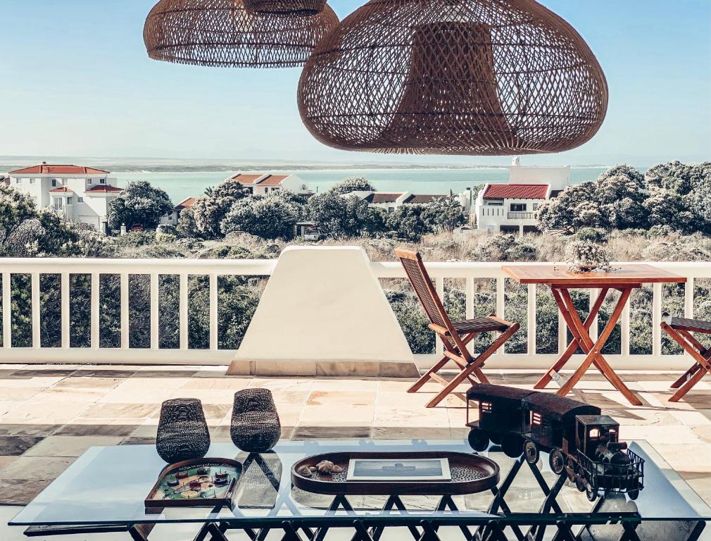 una mesa con cámara y sillas en el balcón en Luxury Home with Stunning Views and Solar Power, en St Francis Bay