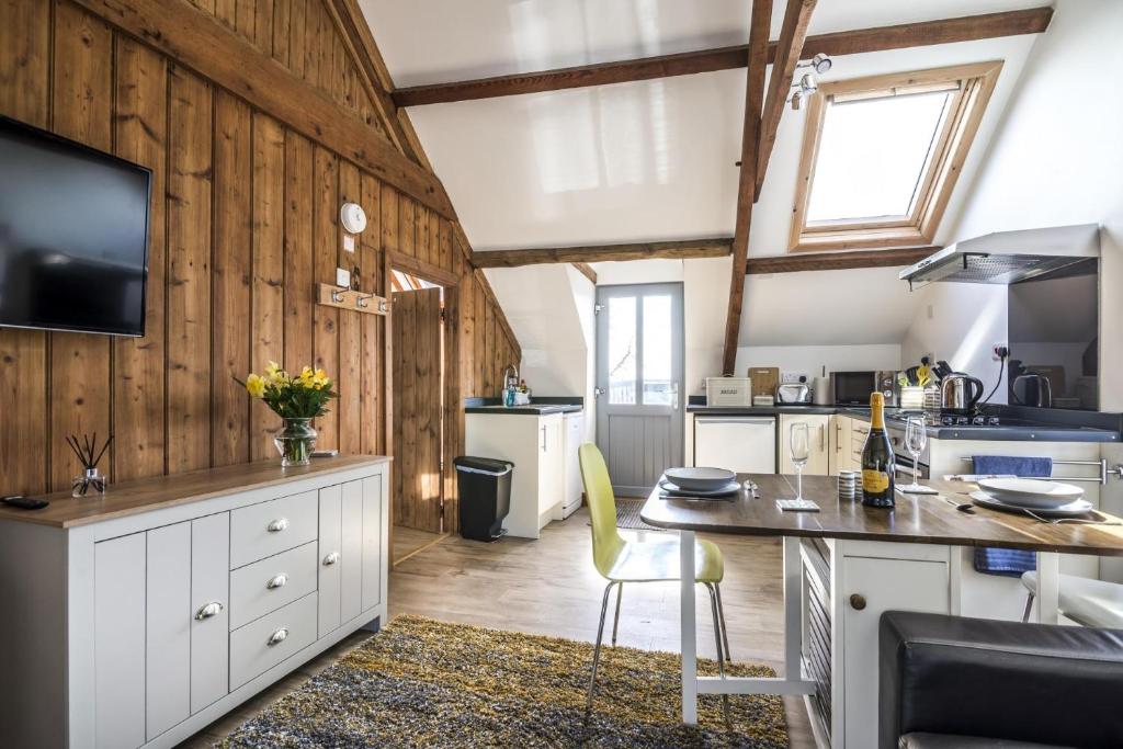 cocina con paredes de madera y mesa con sillas en Ashgrove Farm - 1 Bedroom Apartment - Llawhaden - Narberth, en Narberth