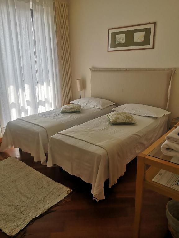 two beds sitting in a room with a window at B&b La corte dei Gelsomini in Ponteranica
