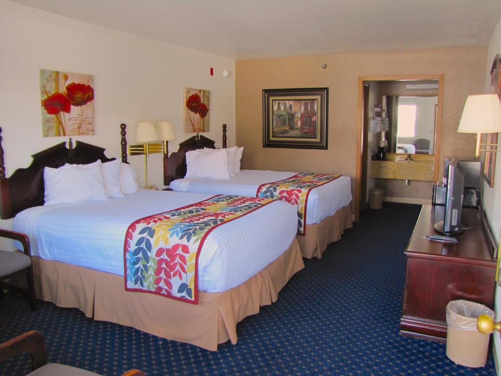 a hotel room with two beds and a television at Dutton Inn in Branson