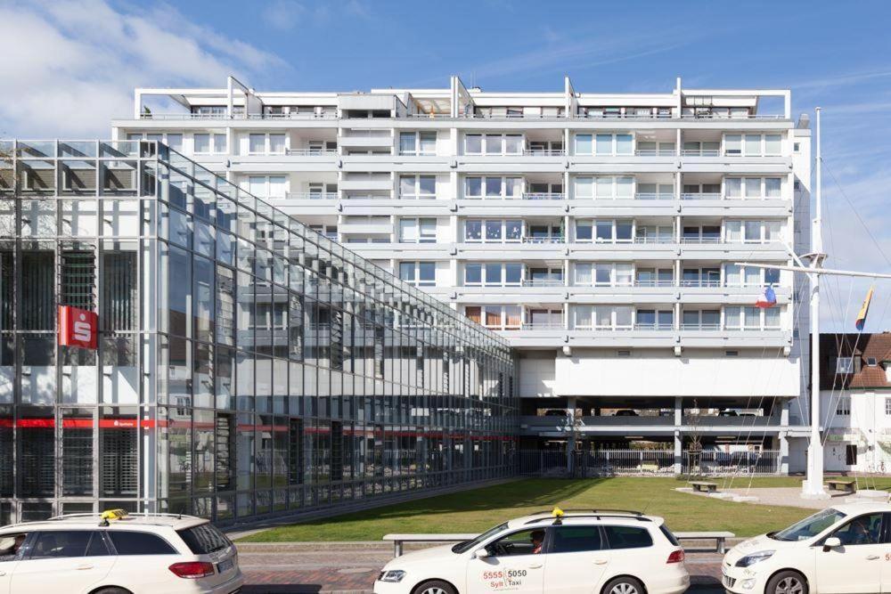 ein großes weißes Gebäude mit davor geparkt in der Unterkunft App. "Syltliebe", Wohnung 6, 1 Etage in Westerland