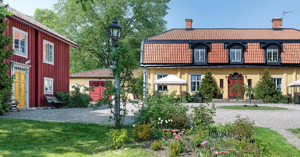 a large house with a red and yellow building at Östa Gård Boutique B&B in Stallarholmen
