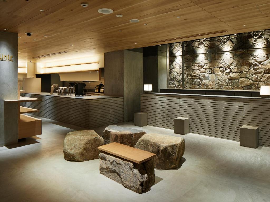 京都的住宿－hotel androoms Kyoto Shichijo，大堂设有两个大岩石和一个酒吧