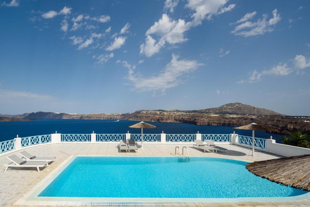 a swimming pool with a view of the water at Villa Maria Rooms in Akrotiri