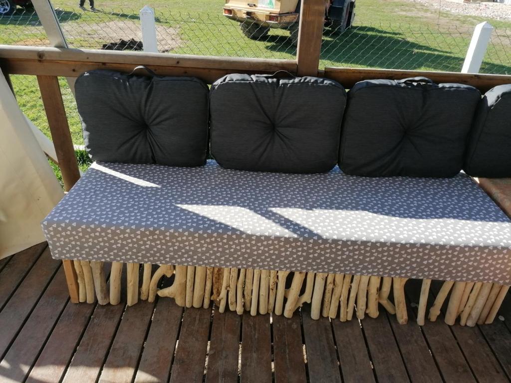 a couch sitting on top of a deck at Le pré vert in Campigny