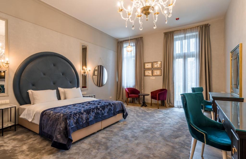 um quarto de hotel com uma cama grande e um lustre em Orbeliani Residence Hotel em Tbilisi