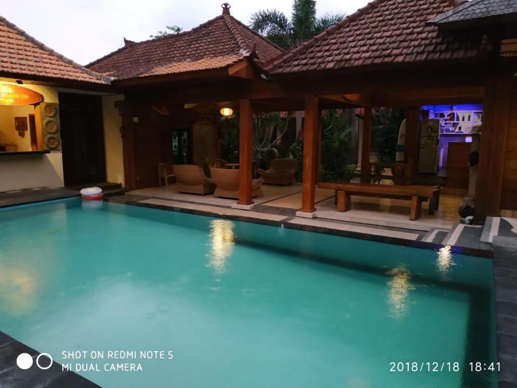 a swimming pool in front of a house at Medewi Beach Inn in Pulukan