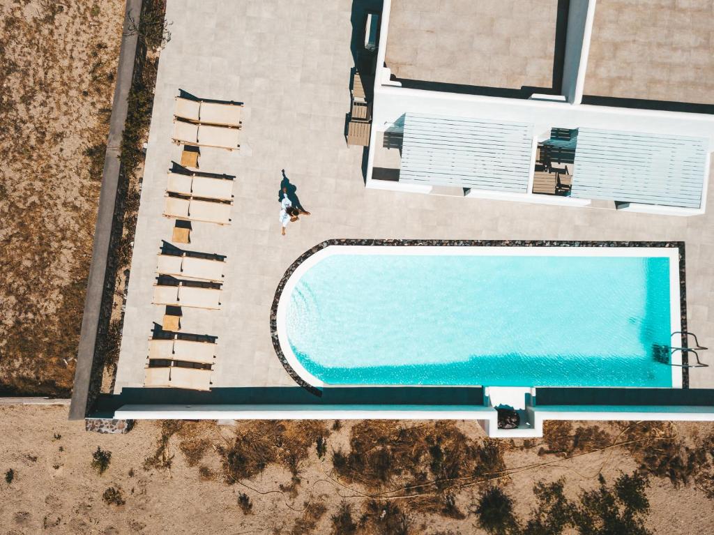 an overhead view of a swimming pool with a person standing next to it at Daylight Hotel in Perissa