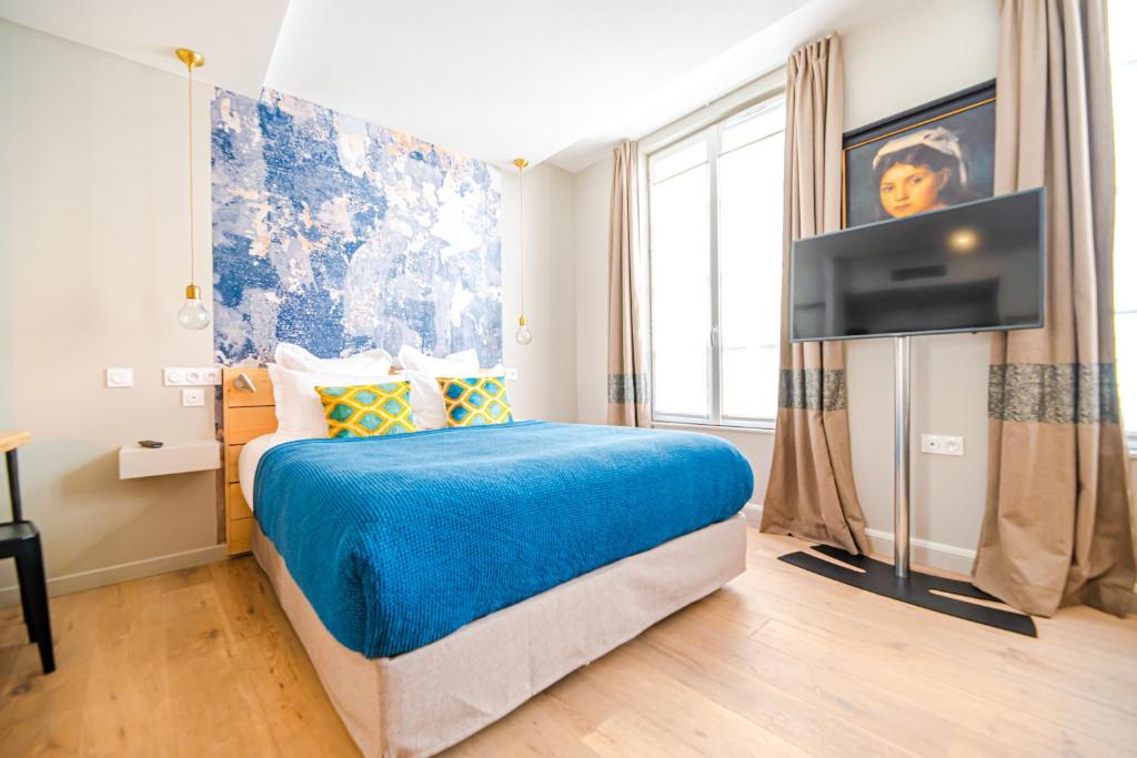 Residence Les Boulevards في باريس: غرفة نوم بسرير وتلفزيون بشاشة مسطحة