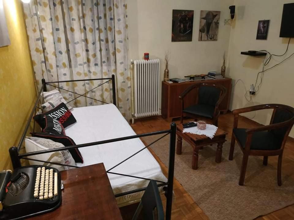 un soggiorno con letto, scrivania e sedia di The Cinema Flat ad Atene