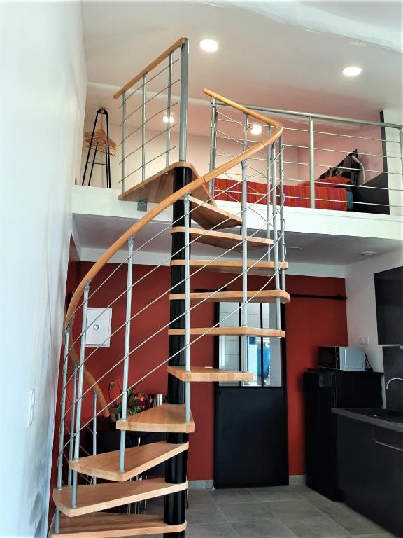 - un escalier en colimaçon dans une chambre aux murs rouges dans l'établissement Gîte de charme au coeur du vignoble de St Emilion, à Génissac