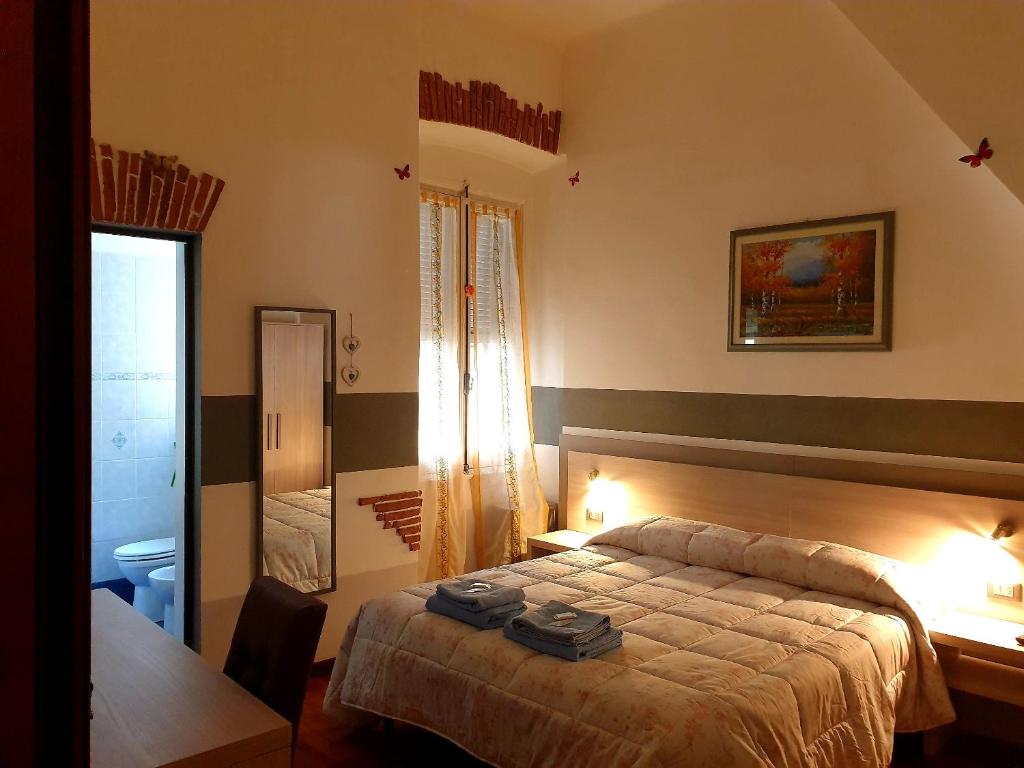 a bedroom with a bed and a desk and a table at Albergo Astro in Genoa