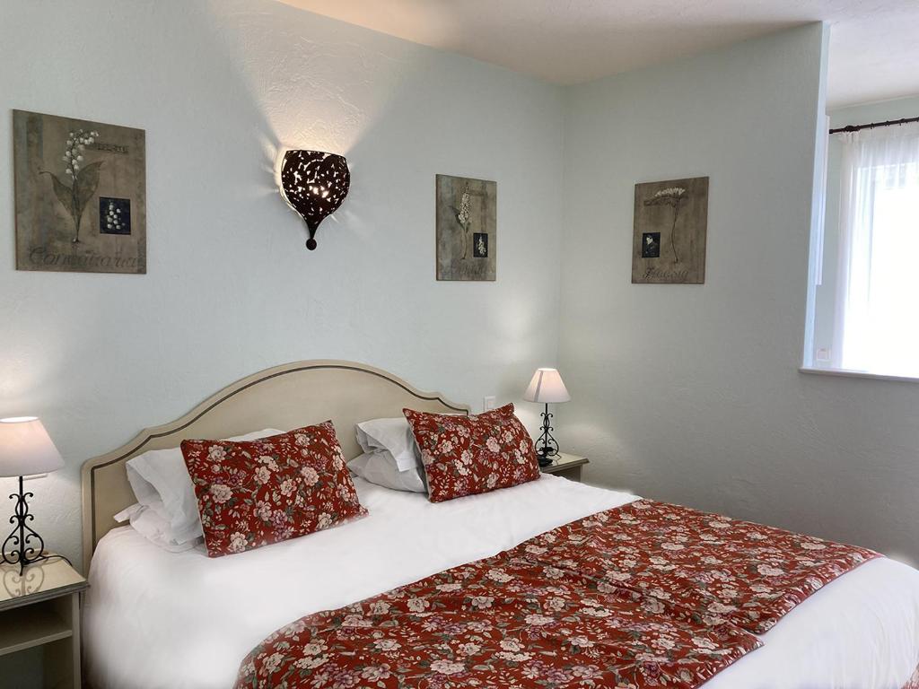a bedroom with a large bed with red pillows at La Résidence du Moulin in Tourrettes-sur-Loup