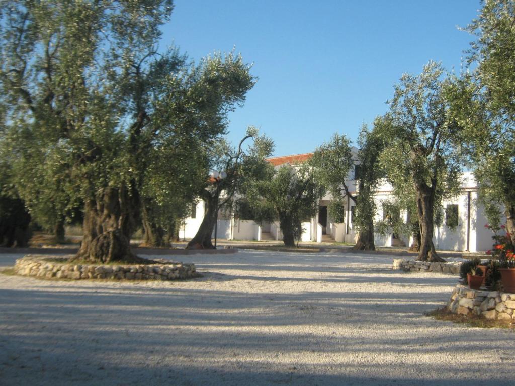 un patio con árboles y un edificio blanco en Villa Medina, en Vieste