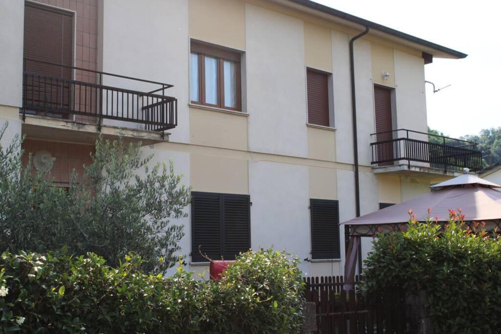 ein weißes Gebäude mit schwarzen Fenstern und einem Zaun in der Unterkunft Appartamento La Cicala in Barga