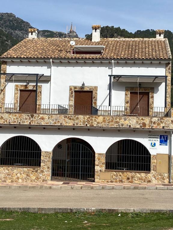 a white building with three gates and a balcony at Apartamentos Mirasierra in Coto Ríos