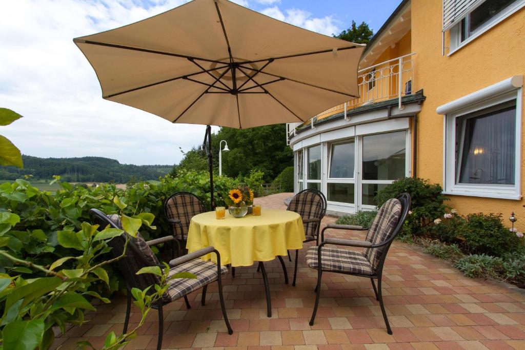 a table and chairs with an umbrella on a patio at Ferienparadies Bodensee Fewo1 in Owingen