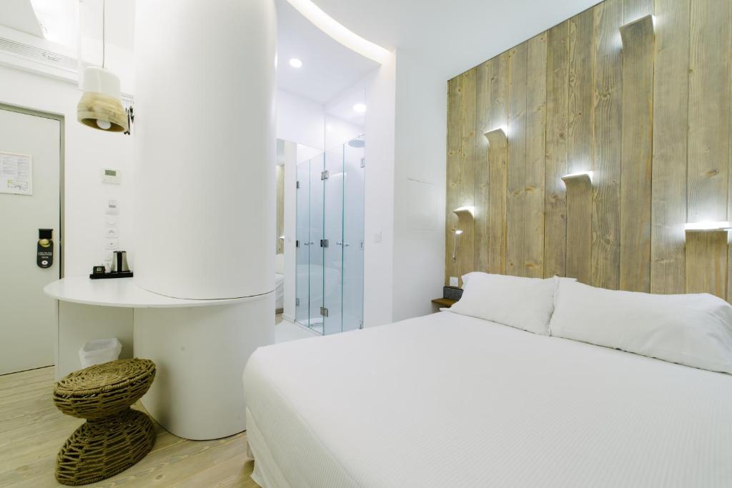 a bedroom with a white bed and a wooden wall at Atypik Hotel in Clichy