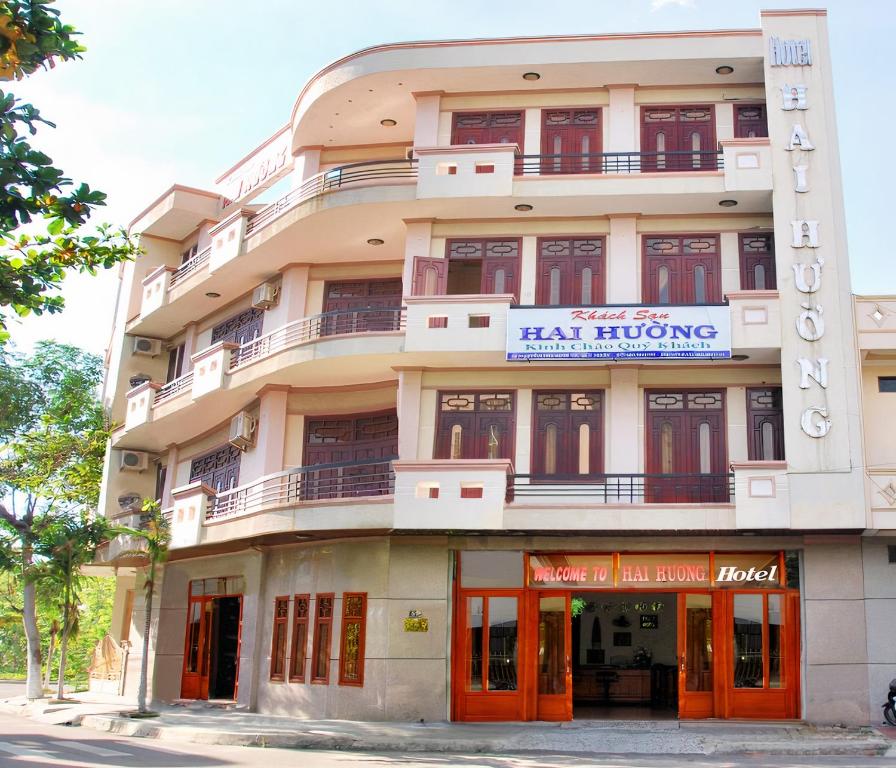 un edificio alto con puertas naranjas y un cartel en él en Hai Huong Hotel, en Quy Nhon